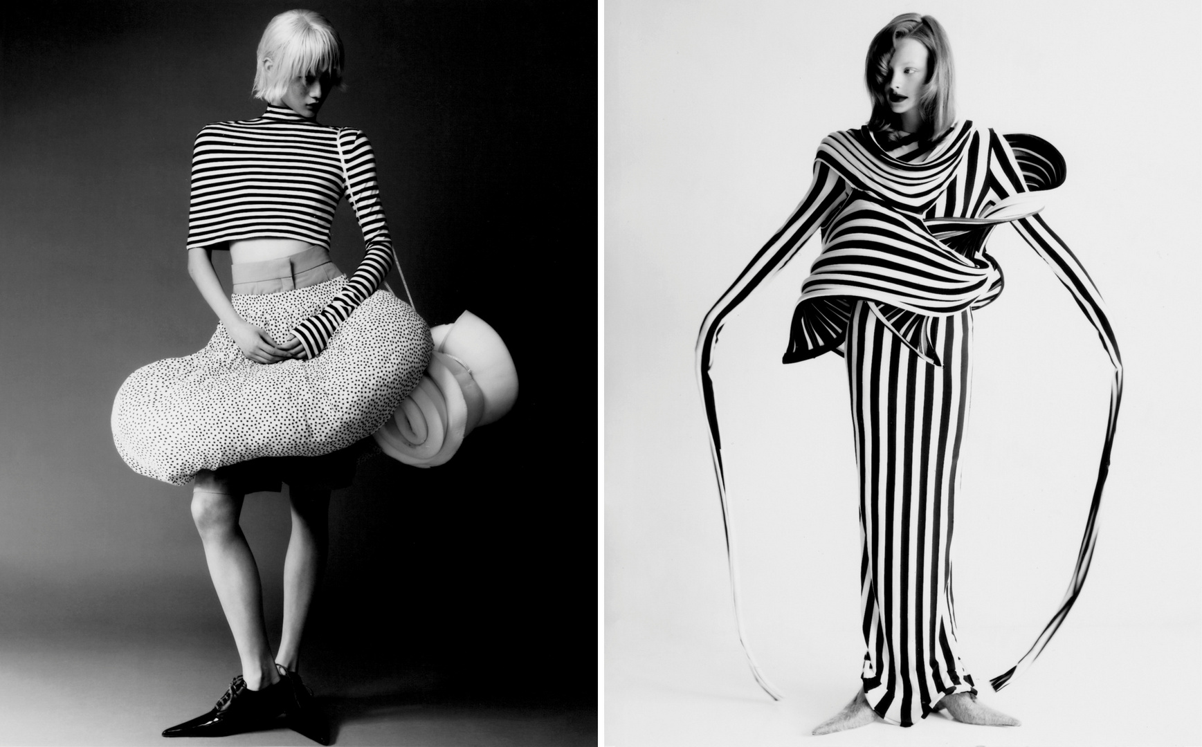 Two fashion models showcase black and white striped avant-garde clothing in a photo studio setting with creative design and unique styling.
