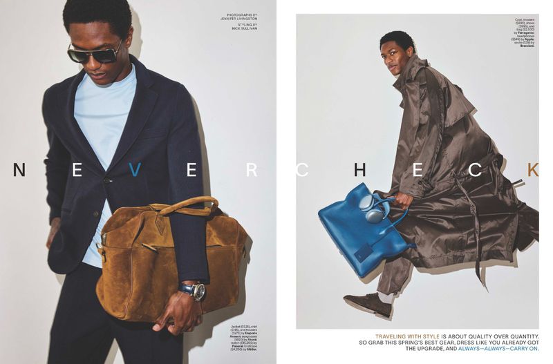 Editorial fashion shot featuring a stylish Black male model wearing a navy suit, sunglasses, and carrying a brown duffel bag indoors.
