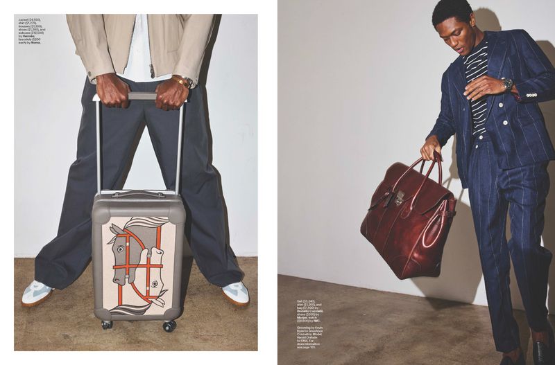 Editorial fashion shot: two Black men present luxury travel with a stylish suitcase and duffel bag in a studio, focusing on high-end accessories.
