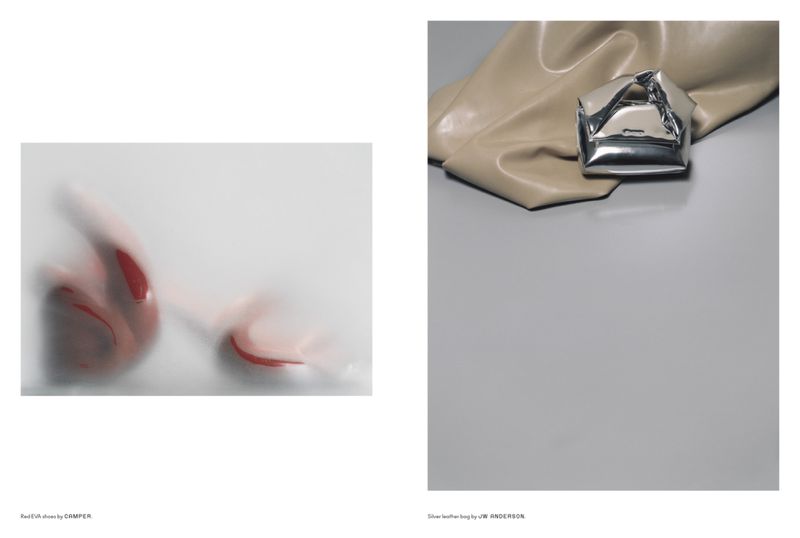 Fashion product shot featuring red EVA shoes behind frosted glass and a silver leather bag on a gray and beige surface.
