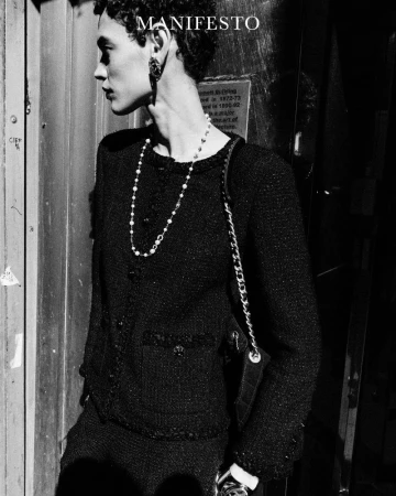 Model Kerolyn Soares wearing a black tweed jacket and pearl necklace in a black and white editorial for Manifesto Magazine.