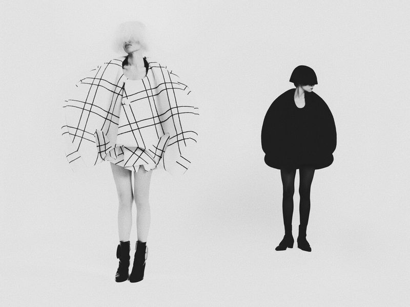 Two women in black-and-white outfits stand against a white background. One wears a plaid dress and boots; the other wears a round black outfit.
