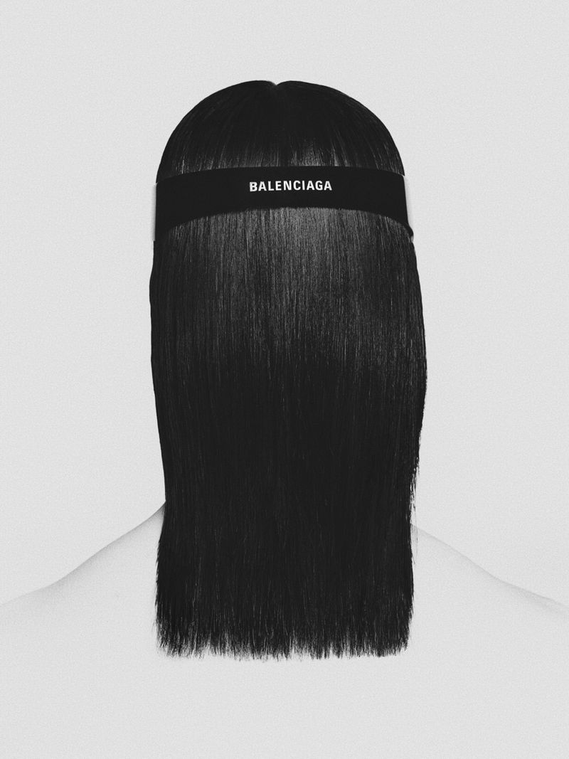 Close-up shot of a woman's dark hair with a Balenciaga headband, set against a soft, light-grey background. Head and shoulders shot.