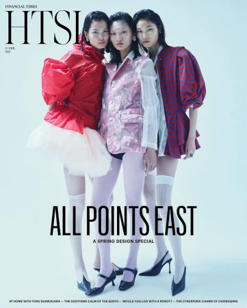 Fashion editorial featuring three Asian models in a studio setting. The models wear bright, avant-garde designs, hosiery, and heels against a white backdrop.
