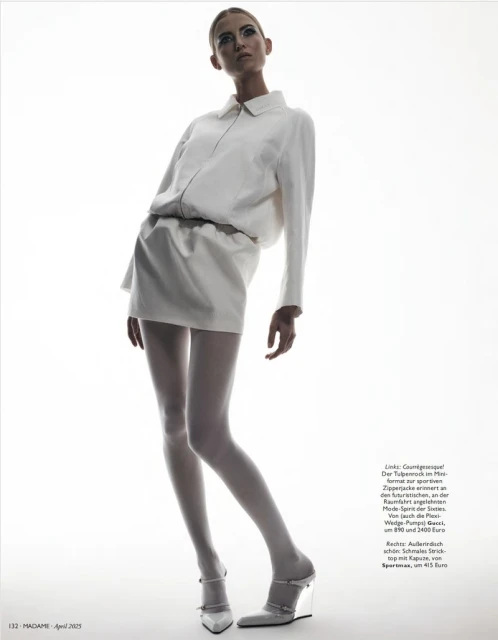 Fashion shot of a fair-skinned adult female fashion model in a white mini dress and wedge heels on a white background in studio lighting.