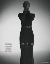 Monochrome fashion portrait of a model in a dark fitted long dress with cutouts against a gradient background.