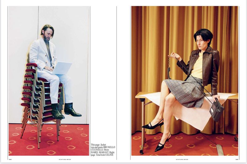 Fashion editorial shot of a man in a white suit on a stack of red chairs using a laptop and a woman in a jacket with a telephone.