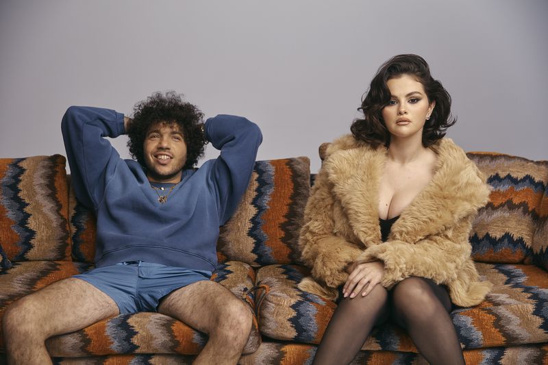 Benny Blanco and Selena Gomez sitting together on a patterned sofa for Interview Magazine photographed by Roe Ethridge