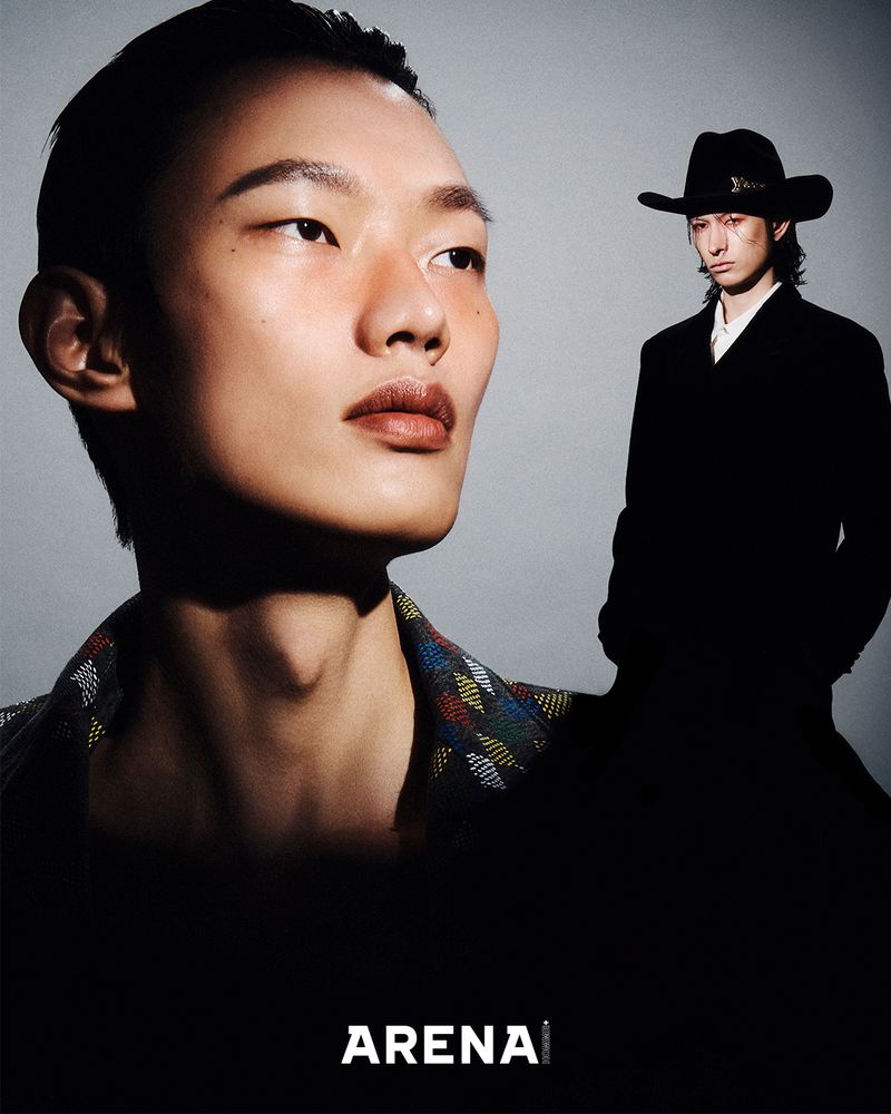 Close-up portrait of an Asian male model alongside a second model in a black suit and hat