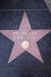 Close-up overhead view of the Devon Lee Carlson star on the Hollywood Walk of Fame embedded in dark terrazzo
