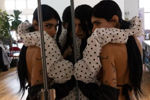 Mia Khalifa reflected in a mirror wearing a white and black polka dot ruffled garment for Autre Magazine by Nick Sethi.