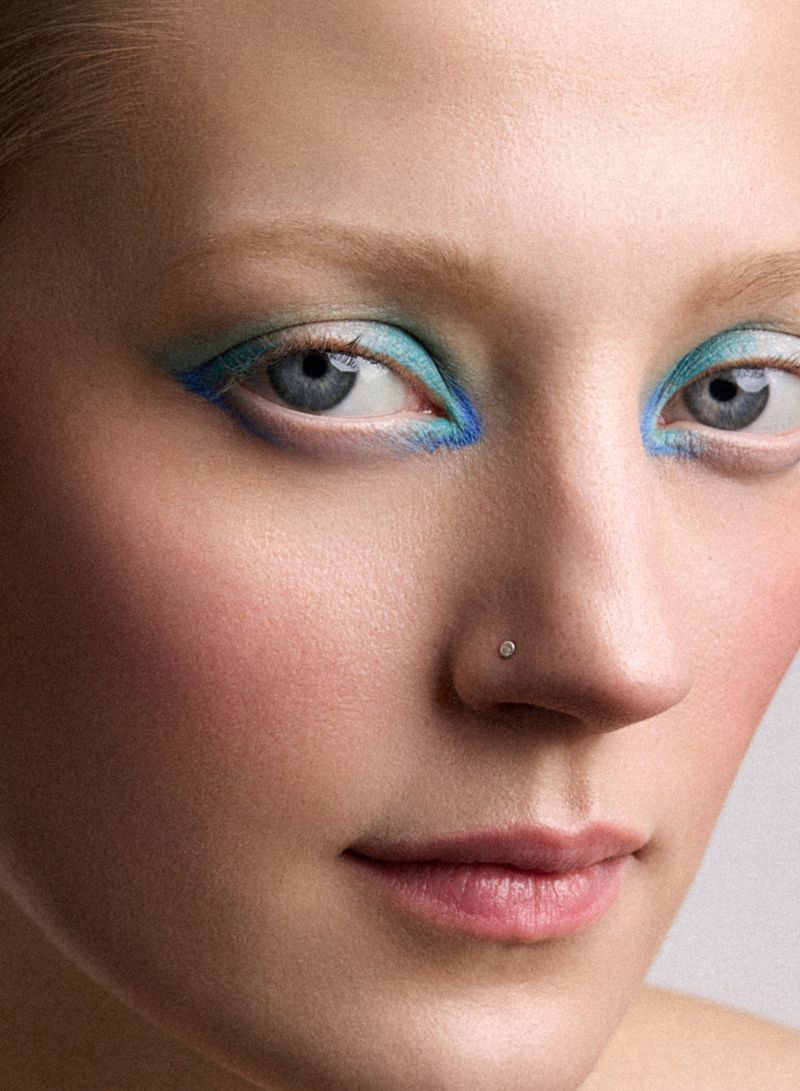 Close-up portrait of a woman with vibrant blue eyeshadow and a small nose stud for Marie Claire Germany