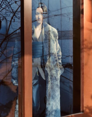 Model seen through glass reflection wearing a textured grey coat for Marie Claire Korea editorial