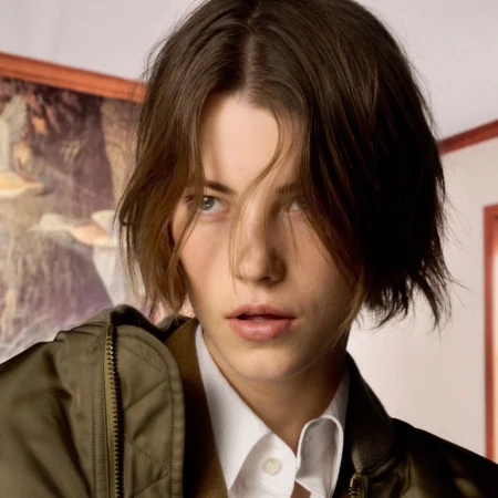 Close-up portrait of a model with short brown hair wearing an olive green jacket and white collared shirt for The Face Magazine.
