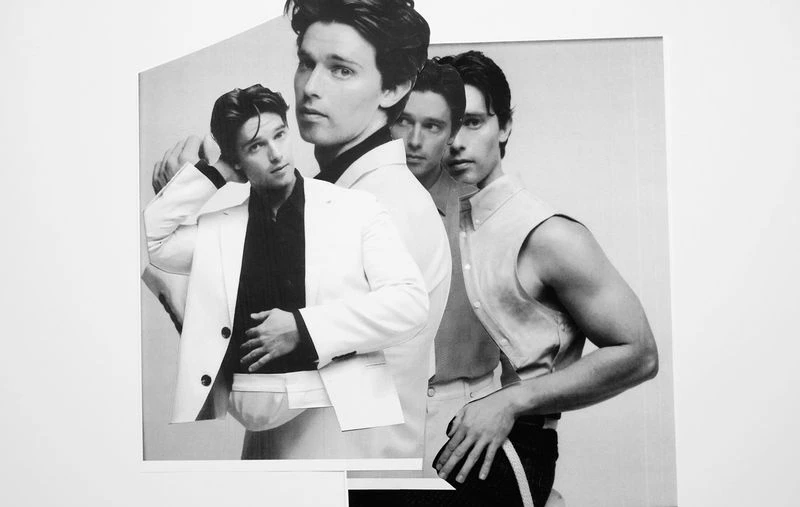 Black and white studio shot features four images of the same adult male, wearing various outfits, in front of a light grey background.