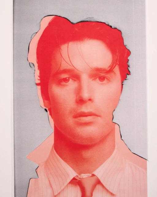 Pop art portrait of a man in a striped shirt with a tie, against a light gray background with coral accents and black outlines.