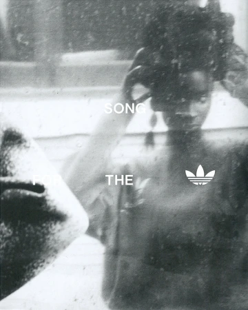 An adult female adjusts her hair in a monochromatic photo with the Adidas logo in the lower right corner, reflected in a mirror.