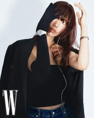 Model wearing a black tube top, black blazer, long black gloves, and denim jeans against a white seamless background for W Korea.