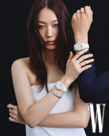 Close-up portrait of a female model wearing white watches and rings, photographed against a black background for W Korea.