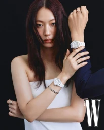 Close-up portrait of a female model wearing white watches and rings, photographed against a black background for W Korea.