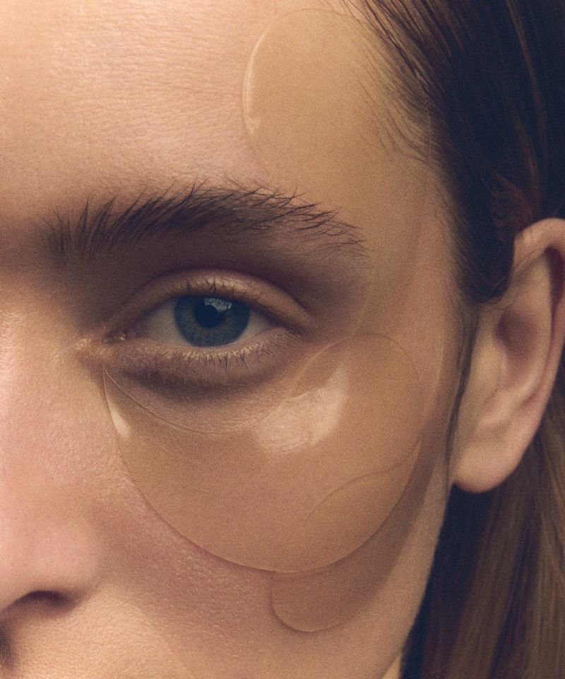 Close-up of an adult female's face with eye patches. Beauty shot of facial care, skincare, eye treatment, and cosmetic wellness.