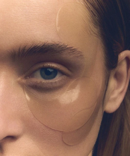 Close-up of an adult female's face with eye patches. Beauty shot of facial care, skincare, eye treatment, and cosmetic wellness.