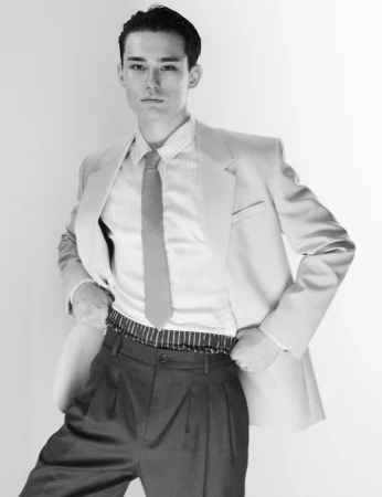 Monochrome fashion portrait of Alex Schlab wearing a tailored blazer and tie for HERO Magazine.