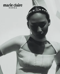 Model wearing a pearl headband and white textured top in a black and white fashion portrait for Marie Claire Korea.