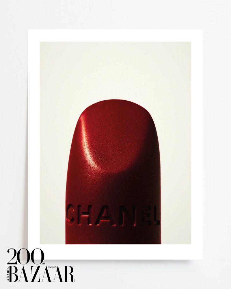 Close-up studio shot of red Chanel lipstick against a clean white background. Beauty and fashion product photography.