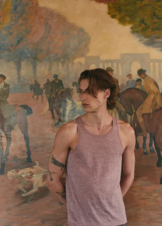 Young adult male in tank top poses against an impressionist painting backdrop featuring horses, dogs, and people in a park.