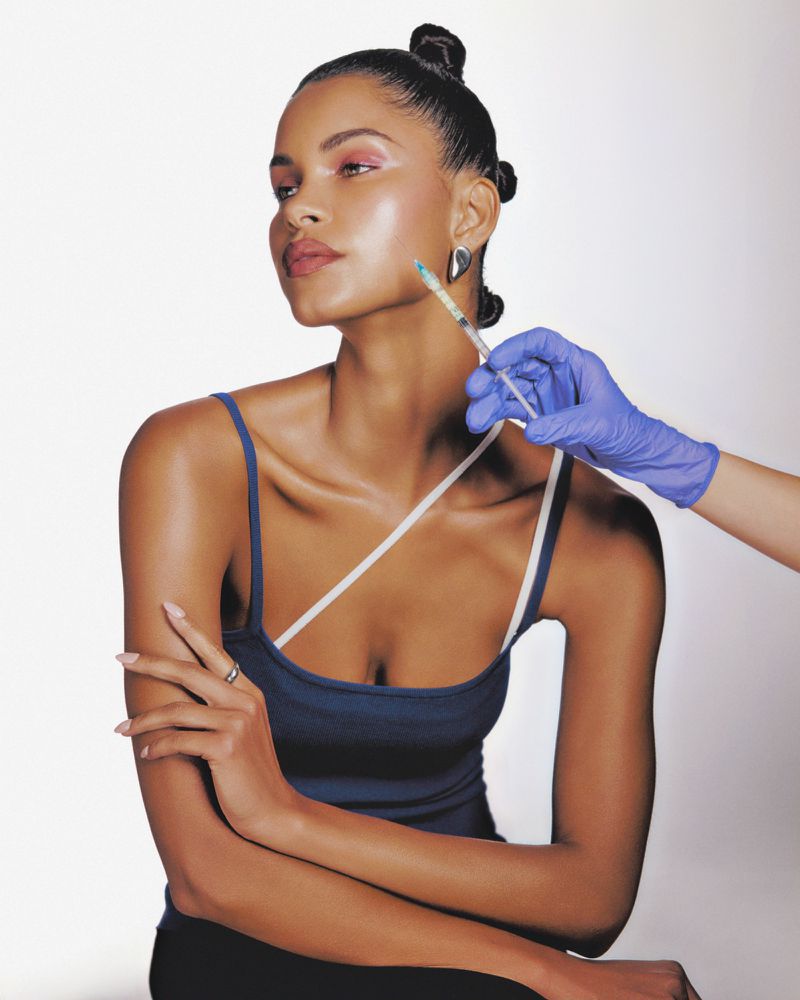 Young woman getting a cosmetic injection on her face, wearing a blue tank top. Gloved hand holding syringe, skincare beauty concept.