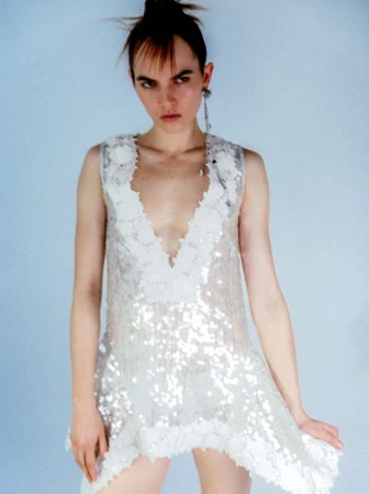 Model in a white sequin dress standing against a pale blue seamless background for WRPD Magazine