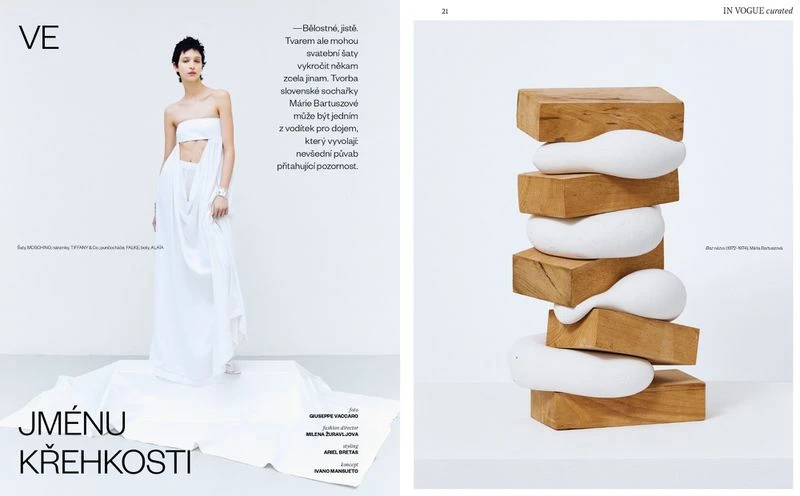 Fashion editorial featuring a woman in a white dress with a modern sculpture made of wood and white filler on a white background.