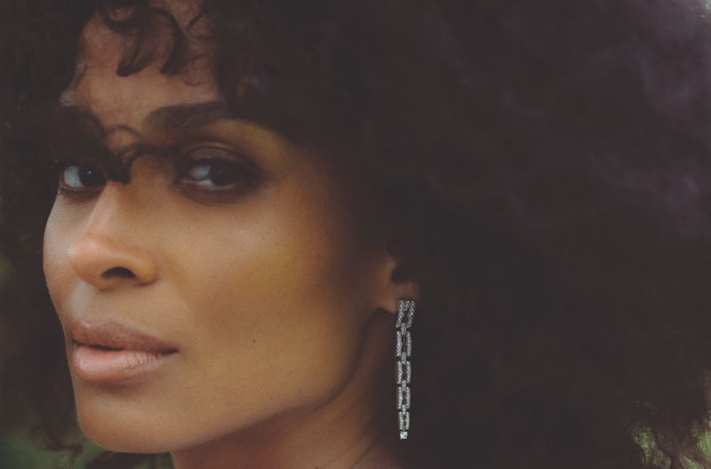 Close-up portrait of Ciara wearing dangling diamond earrings and dark curly hair for L'Officiel Italia editorial