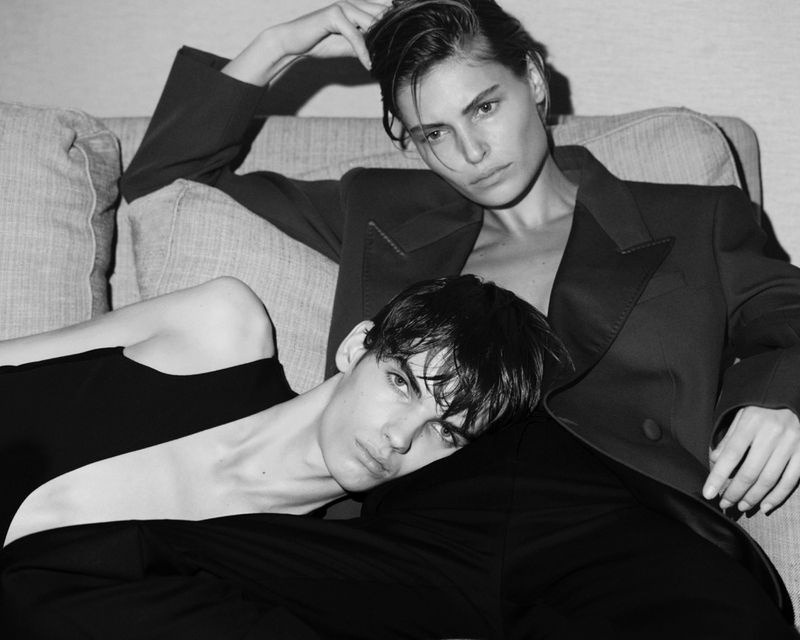 Black and white portrait of two models reclining together on a sofa for Fantastic Man double act project.