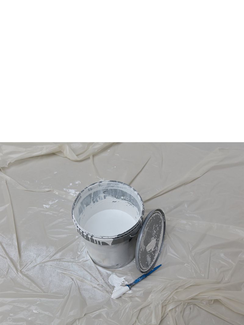 Open can of white paint with paintbrush on white surface, studio lighting, DIY, interior design, paint project, renovation concept.