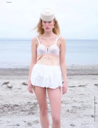 Model Astrid Ostergaard on sandy beach wearing white bra, white shorts, and pillbox hat photographed by Liv Liberg for Self Service.
