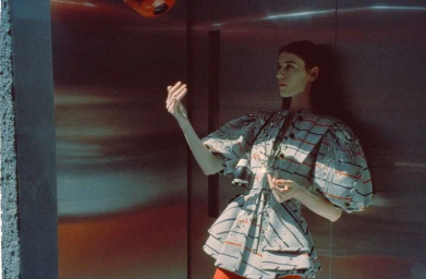 Model in a structured striped top with puffed sleeves posing against a metallic wall for Harper's Bazaar Kazakhstan.