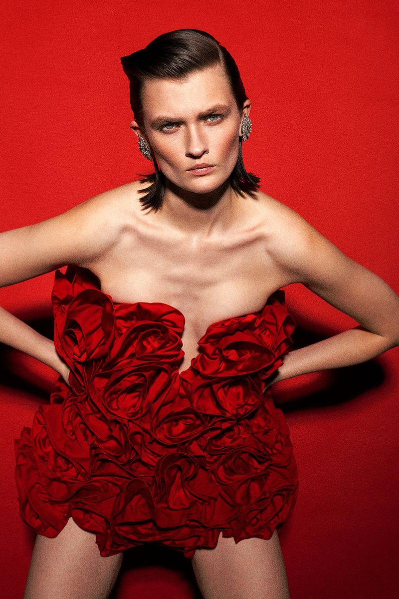Model Lara Mullen wearing a red sculptural rose dress against a vibrant red backdrop for Harper's Bazaar Turkey GECE YARISI DANSI.