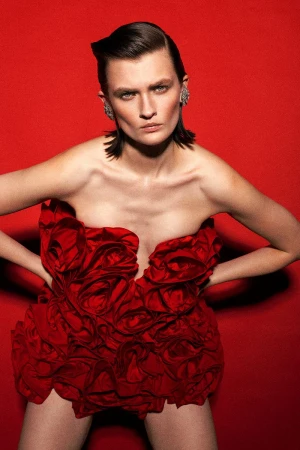 Model Lara Mullen wearing a red sculptural rose dress against a vibrant red backdrop for Harper's Bazaar Turkey GECE YARISI DANSI.