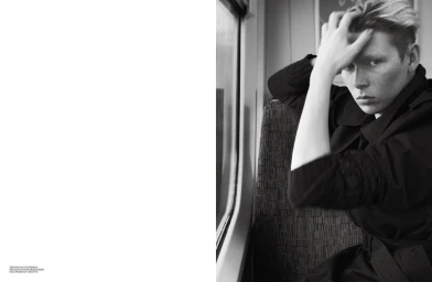 Monochrome editorial portrait of a person sitting by a train window with hand in hair, styled by Max Pearmain for Self Service magazine.