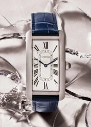 Cartier rectangular luxury watch with white dial and blue leather strap displayed on shattered ice fragments.