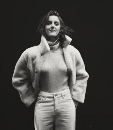 Portrait of a woman wearing a turtleneck sweater and shearling jacket against a dark background for InStyle Australia.