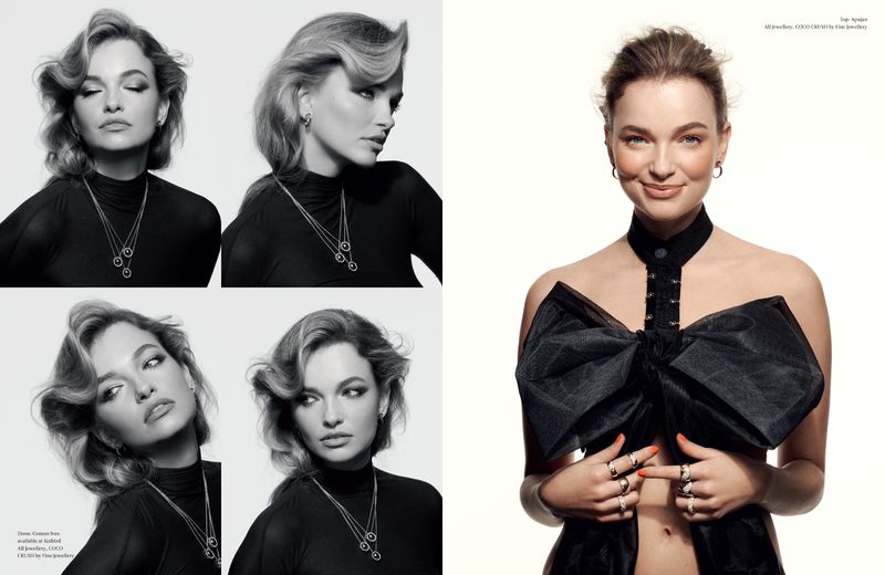 Fashion editorial shot featuring a young woman with light brown hair, wearing a black top and statement jewelry against a bright background.