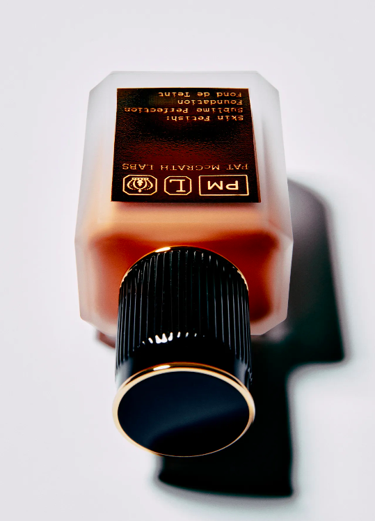 Pat McGrath Labs foundation bottle on white background showcasing the bottle's unique shape, branding, and makeup product inside.