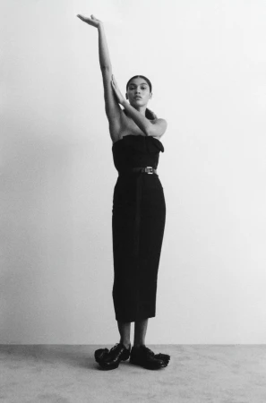 Model Raynara Negrine in a black strapless dress posing against a plain grey studio backdrop for Vogue Adria Clean Lines