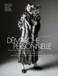 Black and white editorial fashion image featuring a model wearing a long fur coat and flat shoes against a grey gradient background.