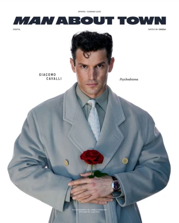 Man in grey coat holds red rose in a studio setting, fashion magazine cover. Spring/Summer 2021 fashion editorial.