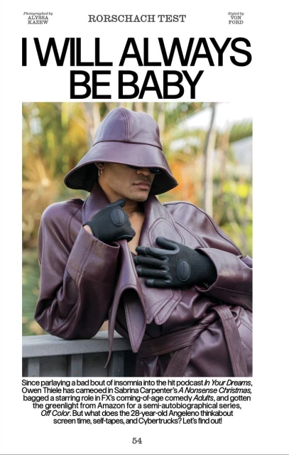 An individual poses outdoors wearing an aubergine-colored leather trench coat and bucket hat, along with black leather gloves, against a natural backdrop.