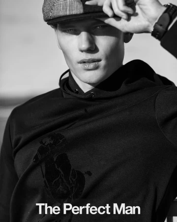 Black and white close-up of a blond male model wearing a cap and black hoodie, with 'The Perfect Man' text overlay.